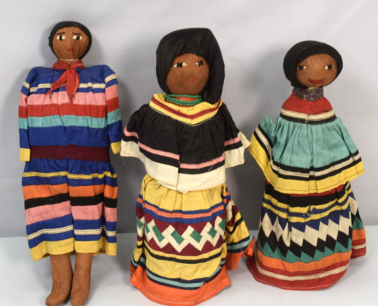 SET OF THREE HANDMADE SEMINOLE DOLLS: Three charming dolls of traditional Seminole Indian craft of the Seminole tribe of Florida. Hand crafted. Natural materials. 11 inches tall. Mid-20th century. Good conditon.