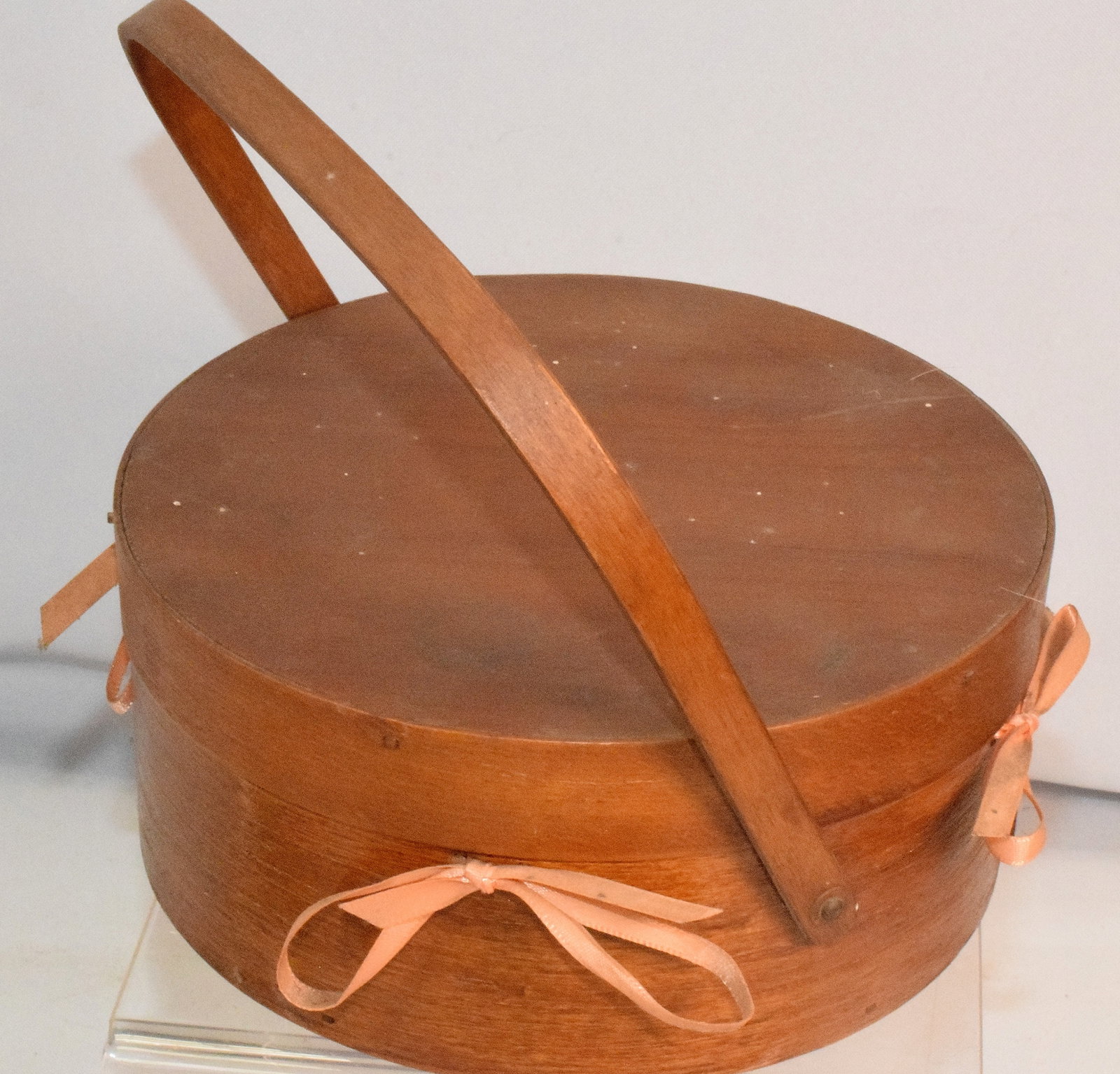 ROUND SHAKER SEWING LIDDED BASKET: Round shaker sewing lidded basket, original refinish spruce with original pink printed paper lining, handle and 4 pink bows. has 4 accessories inside the basket, natural finish. Good condition.