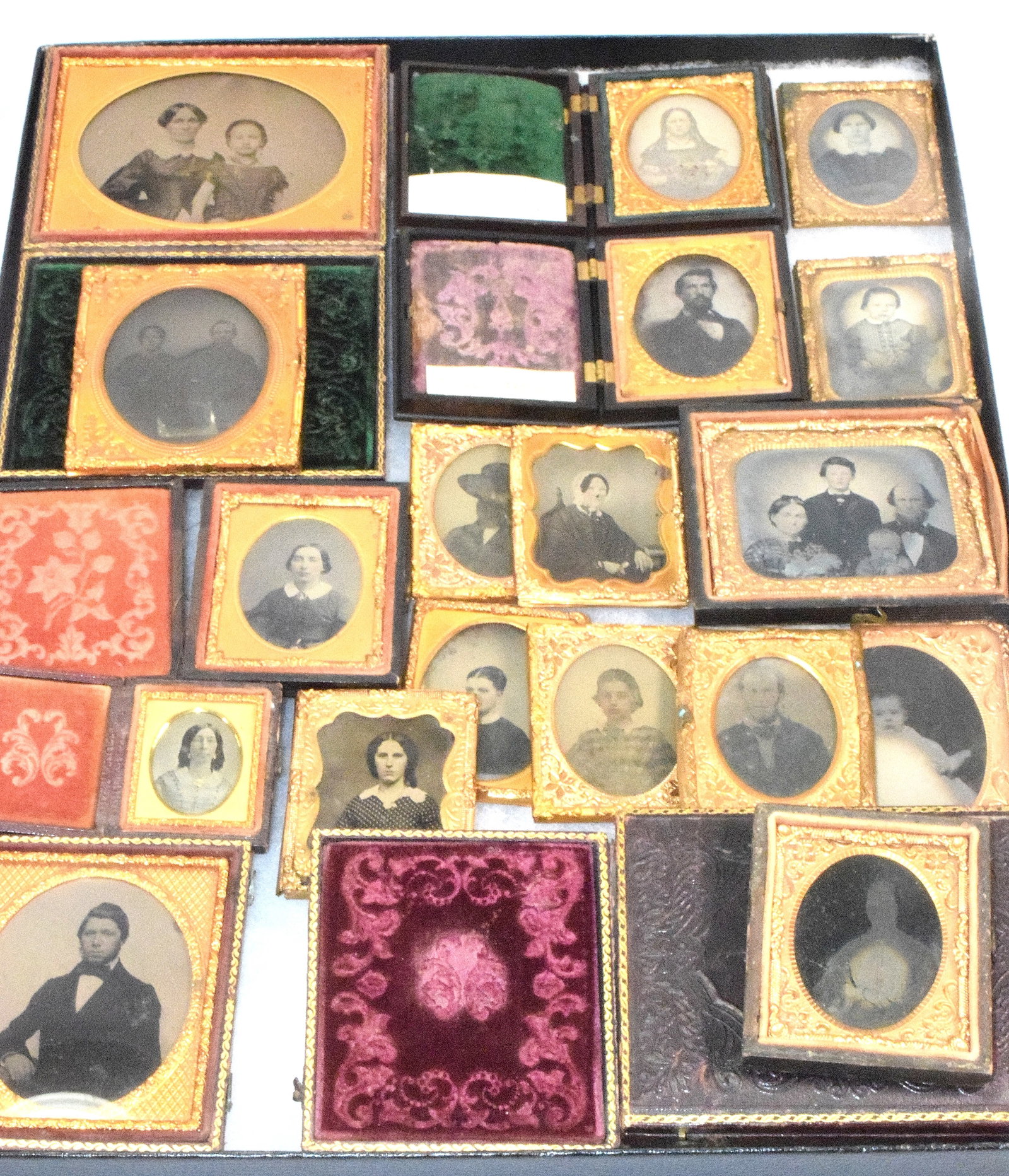 ASSORTMENT OF 18 DAGUERREOTYPES: Assortment includes various sizes of cases, all family images. 2 gutta-percha cases, 1 of them has chips on it. 1 case has no images, some are not in cases. Loose. Good condition. Varioius sizes.