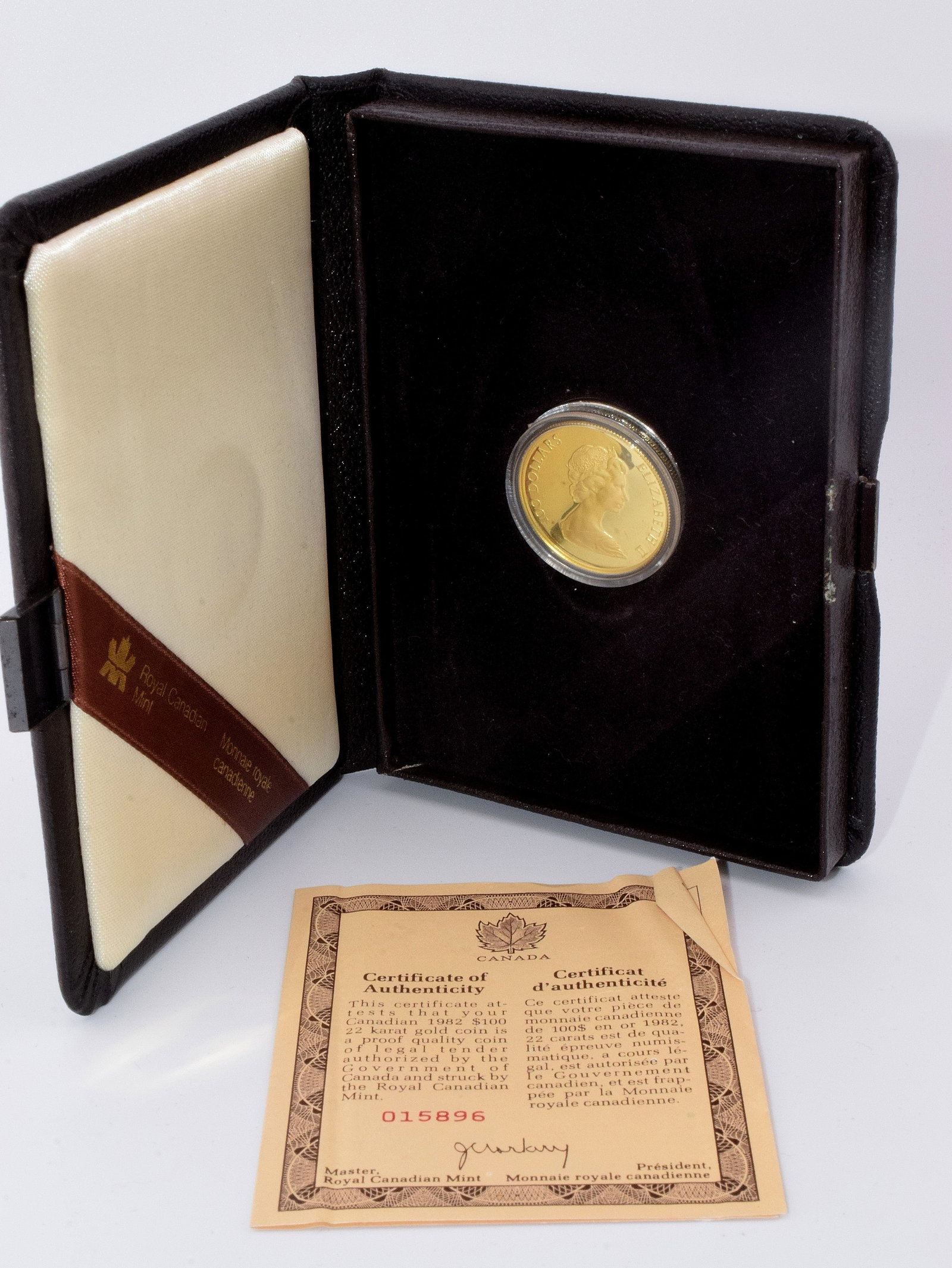1982 CANADA $100 GOLD COIN: 1982 Canada $100 gold coin, good condition, comes in original brown box with a Good conditioned paper describing the significance of the gold Canadian coin, box measures 5 1/2 " x 4 1/2 " .Whites