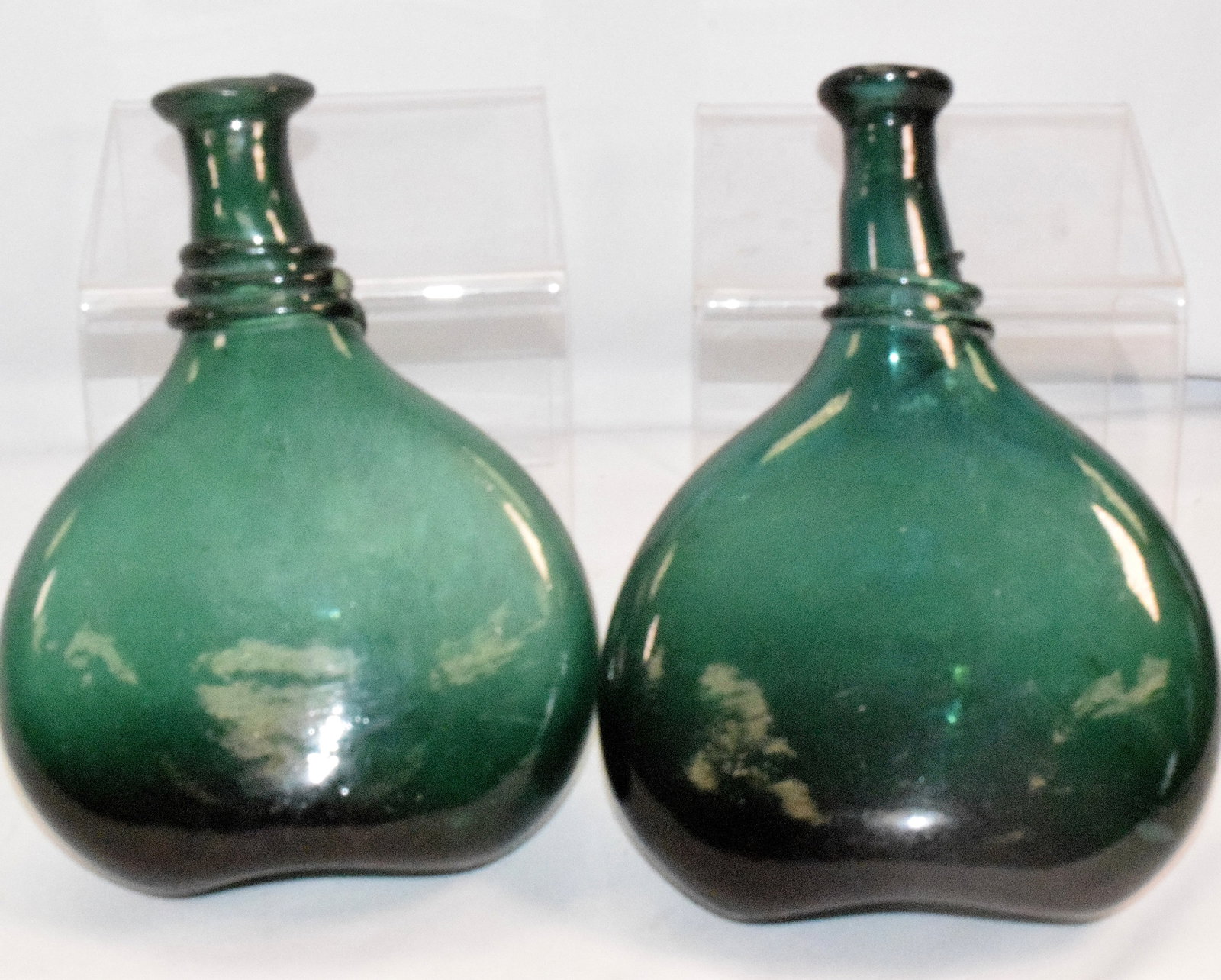 2 HAND-BLOWN GREEN GLASS PESIAN SADDLE FLASKS: 19th century 2 hand-blown daek green glass Persian saddle flasks with applied rings around the neck, Good condition, designed to be easy to carry, these were mostly tucked into saddles or coats and we