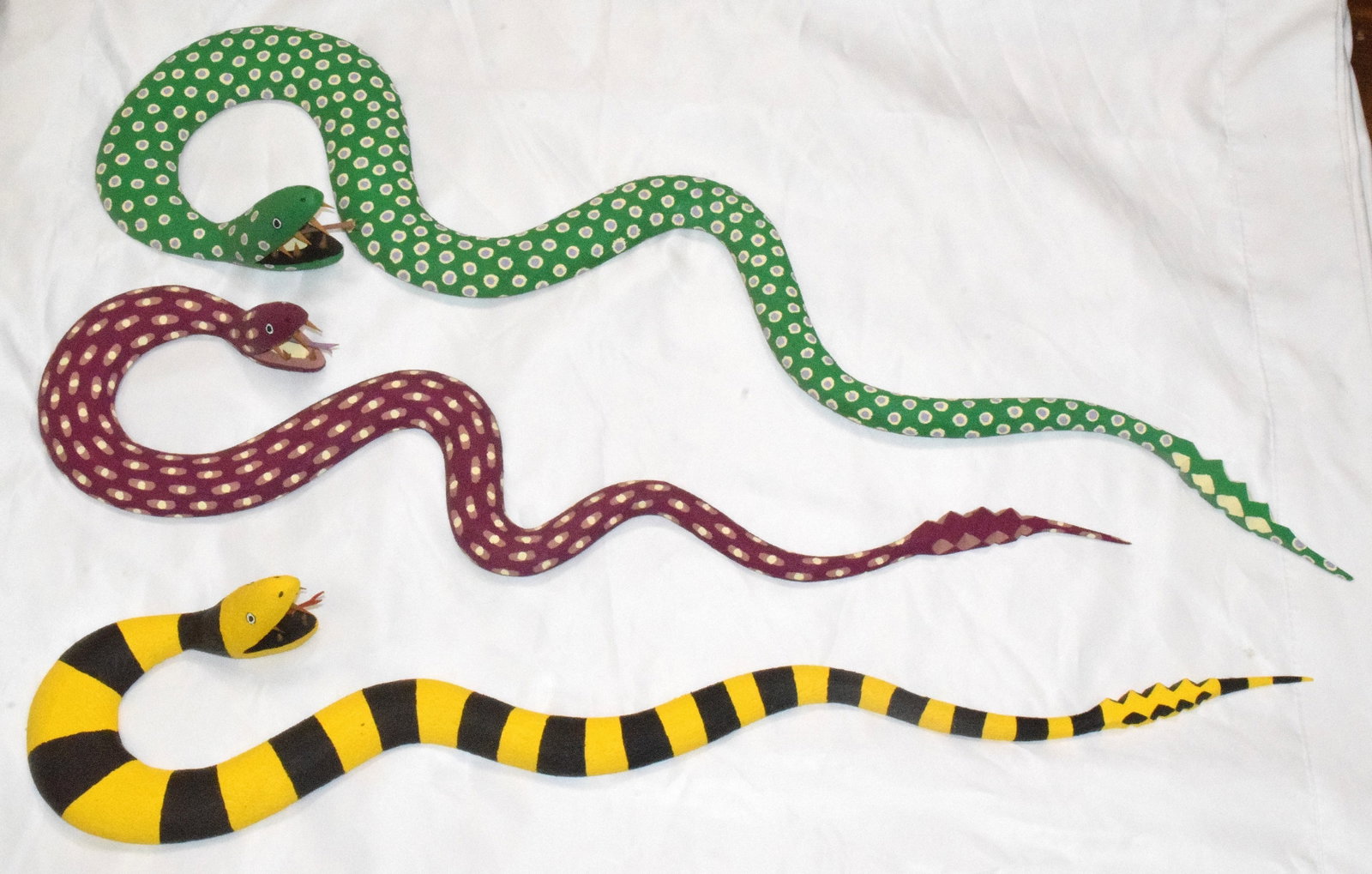 3 PAUL LUTONSKY, FOLK ART WOODEN SNAKES: Paul Lutonsky (American, born 20th century). Untitled - Folk Art Snakes - painted wood, signed and dated to the underside. Ca 1988 and two 1990. Various sizes and colors. Good condition.