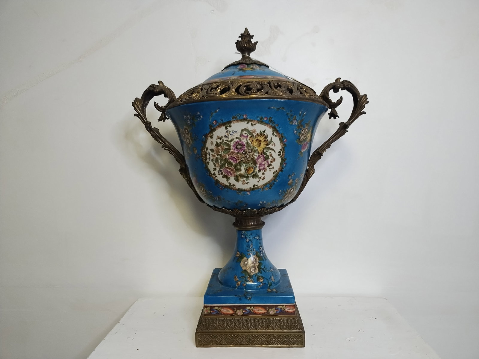 Blue Large Porcelain - Bronze Mount Center Piece Urn w/ Lid: Blue Large Porcelain - Bronze Mount Center Piece Urn w/ Lid 24"H-Hand painted Blue porcelain -Hand Crafted.Has a Beautiful Bronze Heavy Scroll leaf handle...Excellent Condition. Measurements Approx: W