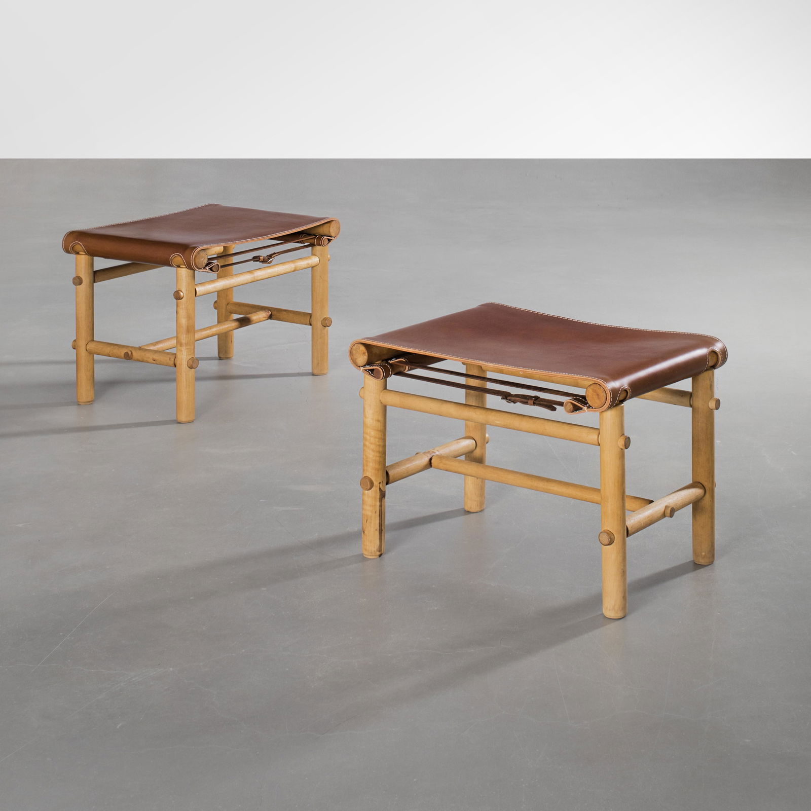 Maija Heikinheimo: A pair of rare ”Safari” stools with brown leather, designed by Maija Heikinheimo manufactured by Noormarkun KÃ¤sityÃ¶ for Artek.. Height: 40cm, stool top: 57x40cm. Signed -