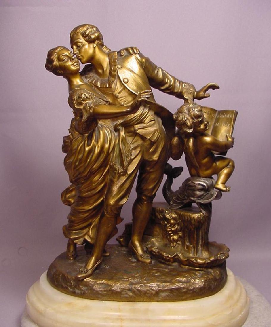 Romantic Antique Polychrome Bronze Sculpture La Monaca: Romantic and beautiful antique polychrome bronze sculpture of two lovers embracing while a gilt bronze cherub reads from the book of love as he sits on a silver polychrome dolphin that is resting on a