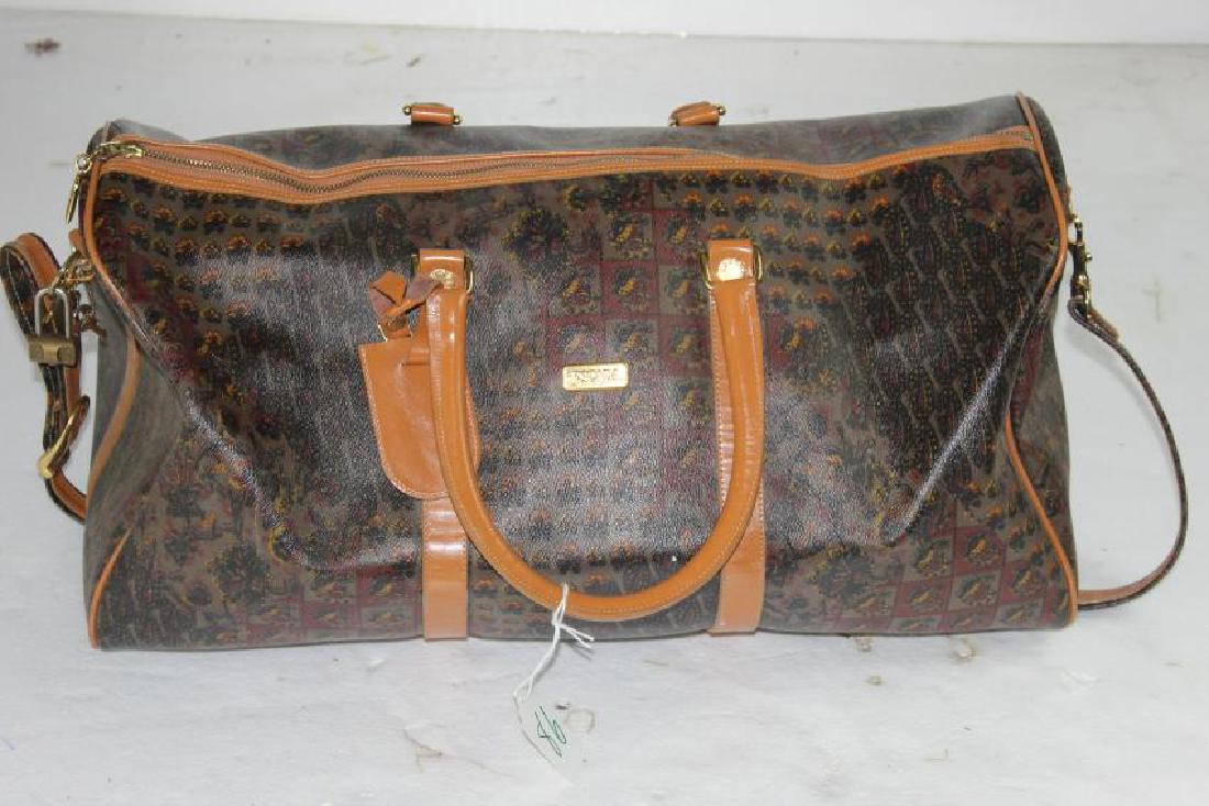 Escada Carry On Multicolored Luggage: This is an Escada Multicolored Carry On Luggage Bag. It has a brown background with multicolored floral designs on it. Come with a brown strap and brown handles. Measuring at 22in x 9in and 11 in. Dee