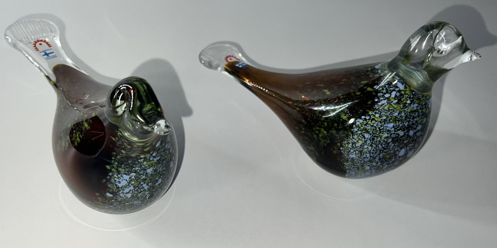 (2) Humppila Bird Glass Figurines: (2) Humppila Bird Glass Figurines ; both figurines are in good condition, no chip,s or flea bites; each bird is a brown with green and blue specs; They both measure approx. 6.5 inches in length by 5 i