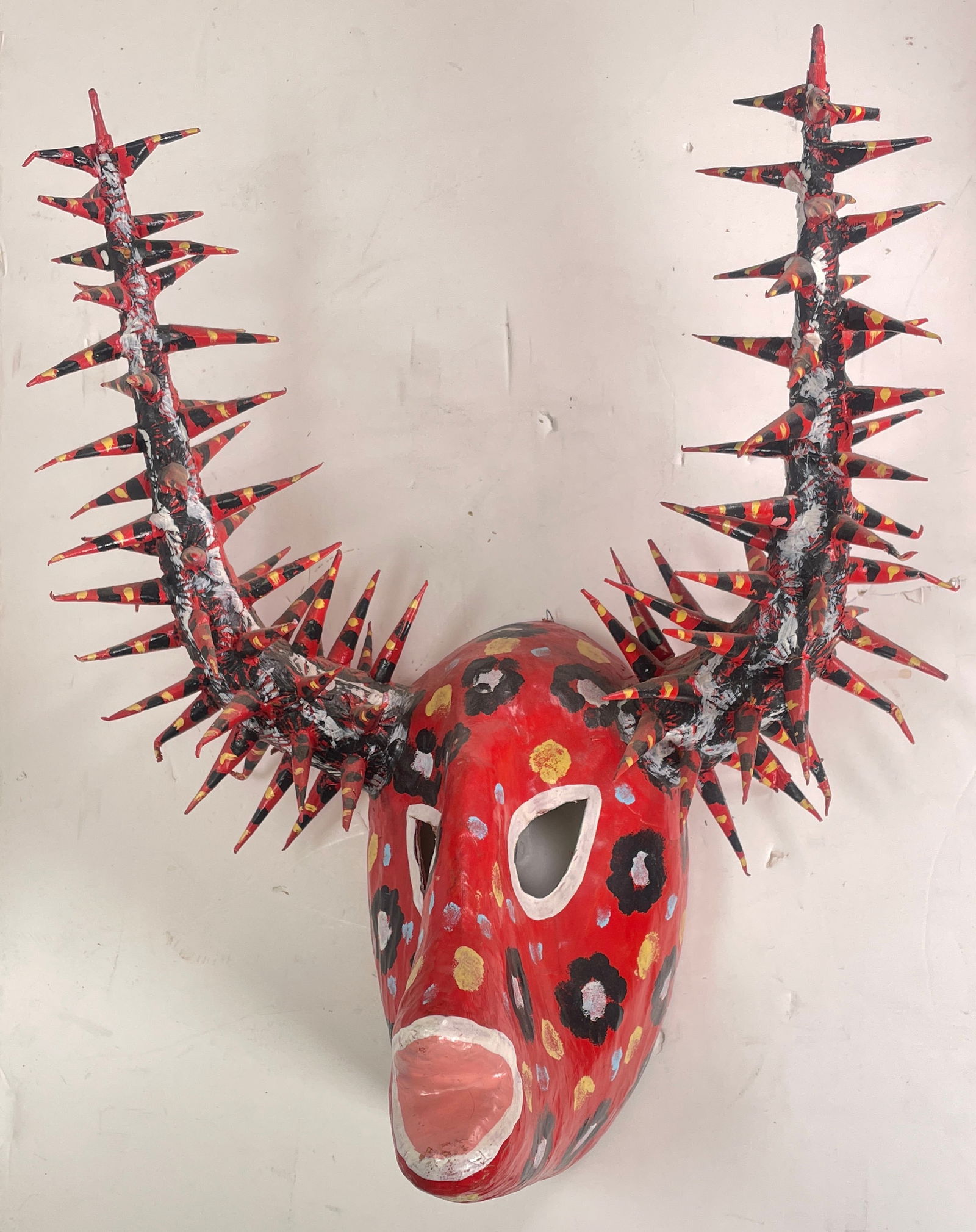 Vintage 1960s-1970s Papier-mâché Mardi Gras Abstract Ram Mask Decor: This is a vibrant mask, vintage from the 1960s-1970s. It is made out of Papier-mâché for Mardi Gras. This mask features a red base adorned with intricate an intricate floral design around the face.