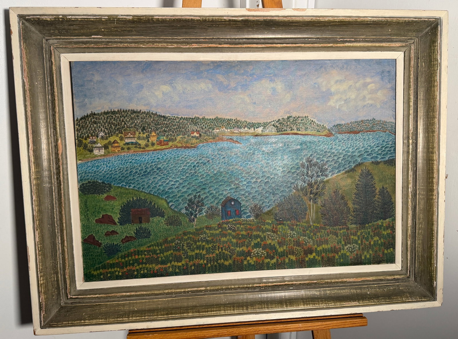 Baileys Island by Mark Baum (Oil On Canvas): A beautiful piece of artwork, It depicts a serene landscape with a body of water, trees and a small village nestled along the shore. The style is color and naive, giving it a wonderful handcrafted fee