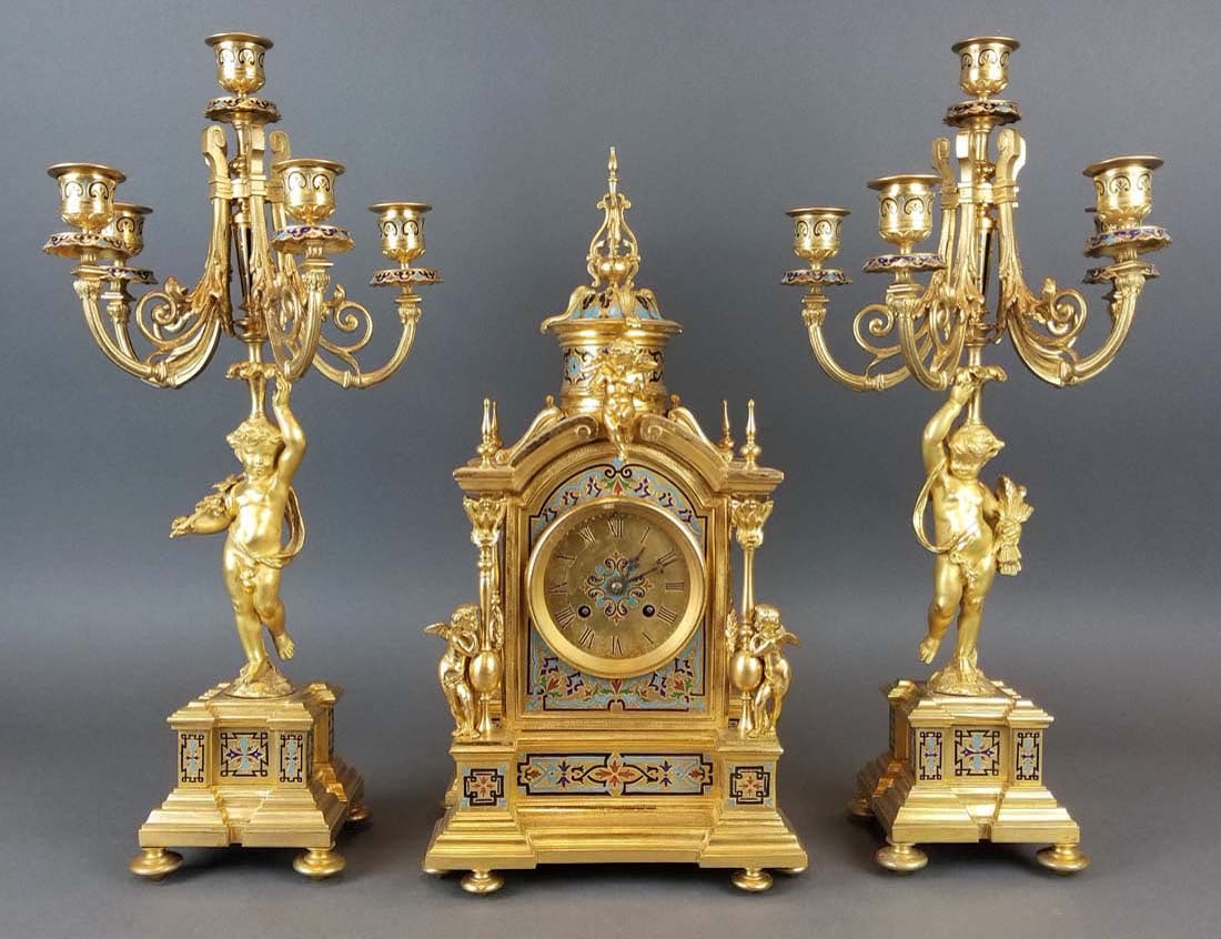 19th C. French Champleve Enamel Figural Clockset: 19th C. French Champleve Enamel Figural Clockset. The clock measures H: 16 1/2" W: 8 1/4" and the candelabras measures H: 18 3/4" W: 9"