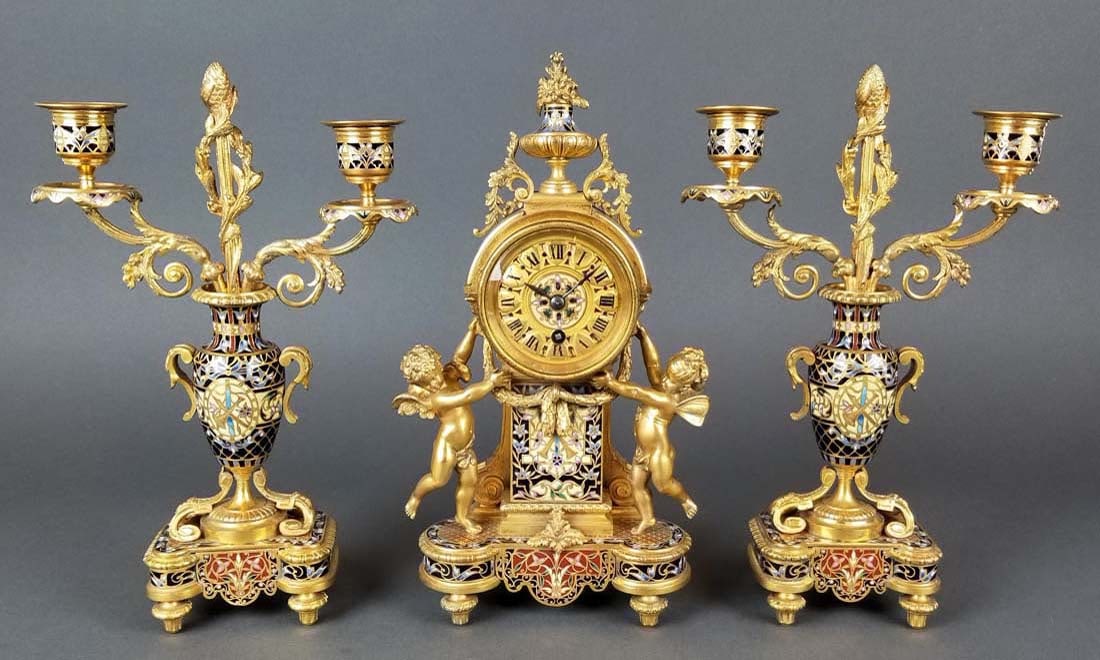 Exceptional French Champleve Enamel Figural Clockset: Exceptional French Champleve Enamel Figural Clockset. The clock measures H: 11" W: 5 3/4" and the candelabras measure H: 10 1/2" W: 7"