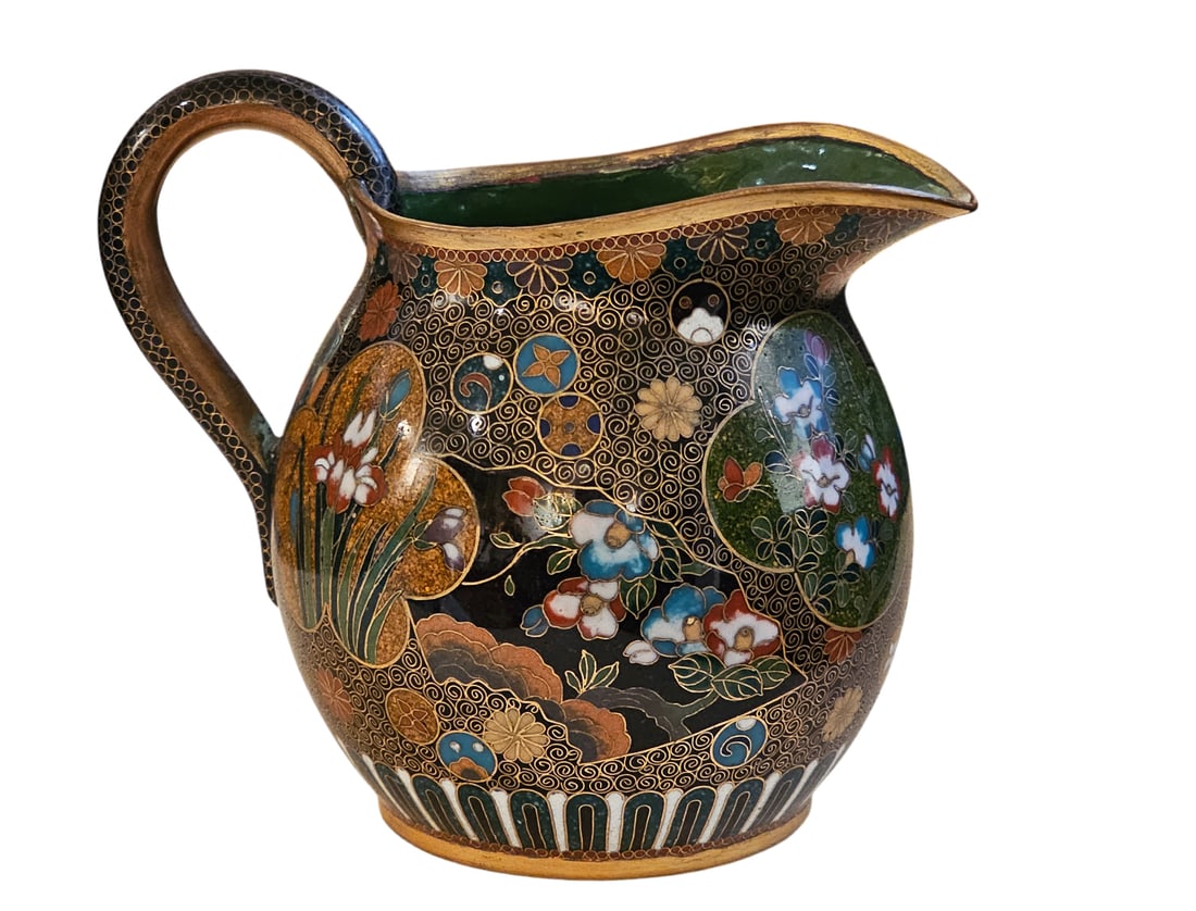 19th C. Japanese Cloisonne Creamer: 19th C. Japanese Cloisonne Creamer. It futures a dark background with intricate floral and scroll motifs. H 3 1/2"