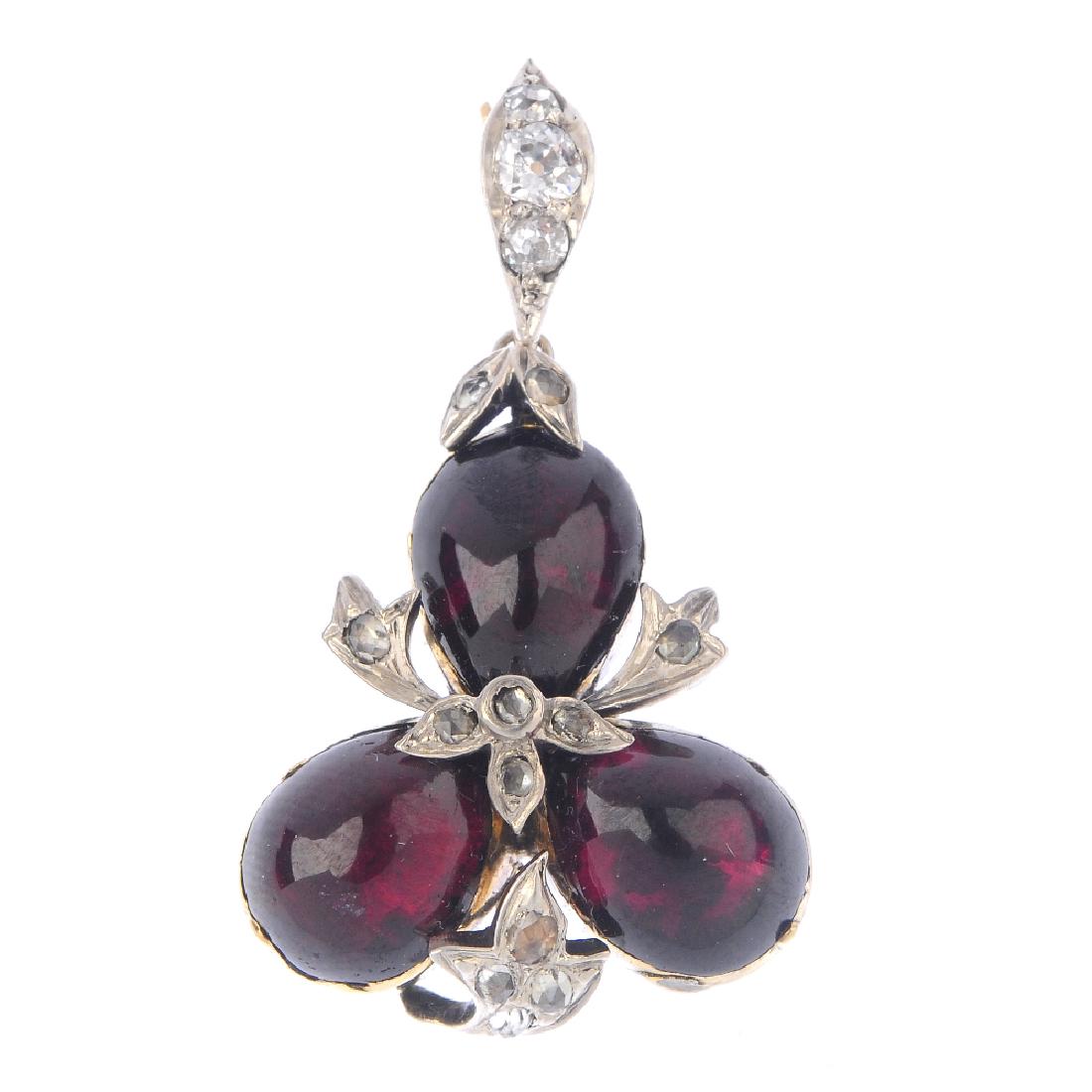 A garnet and diamond pendant. The pear-shape garnet (1 of 2)