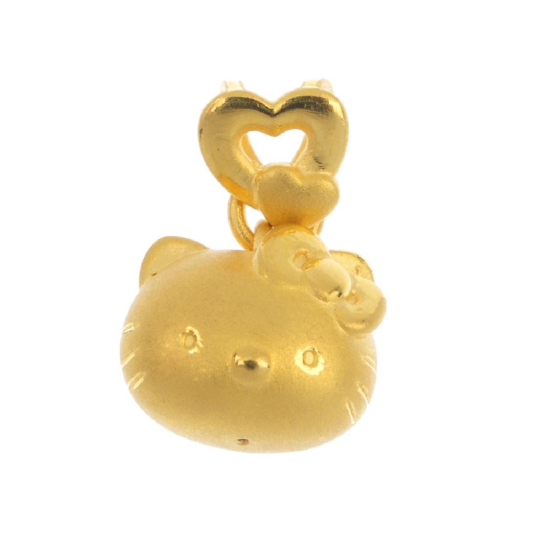 HELLO KITTY - a pendant. The textured 'Hello Kitty': HELLO KITTY - a pendant. The textured 'Hello Kitty' head with bow, suspended from an openwork double heart surmount. Marked Sanrio. Length 2cms. Weight 1.9gms.