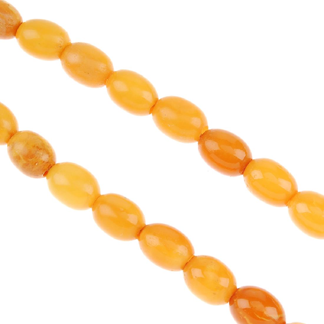 A natural amber bead necklace. The single row of (1 of 2)