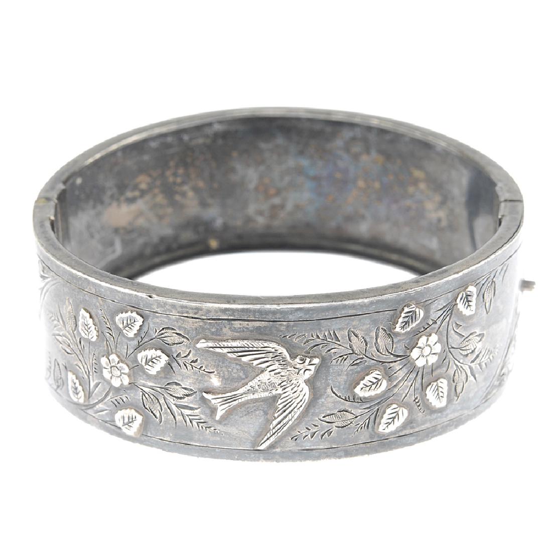 Two charm bracelets, a hinged bangle and a selection of: Two charm bracelets, a hinged bangle and a selection of guard chains. The silver hinged bangle with applied flower and bird design to the half-bangle, together with a flat curb-link charm bracelet, su