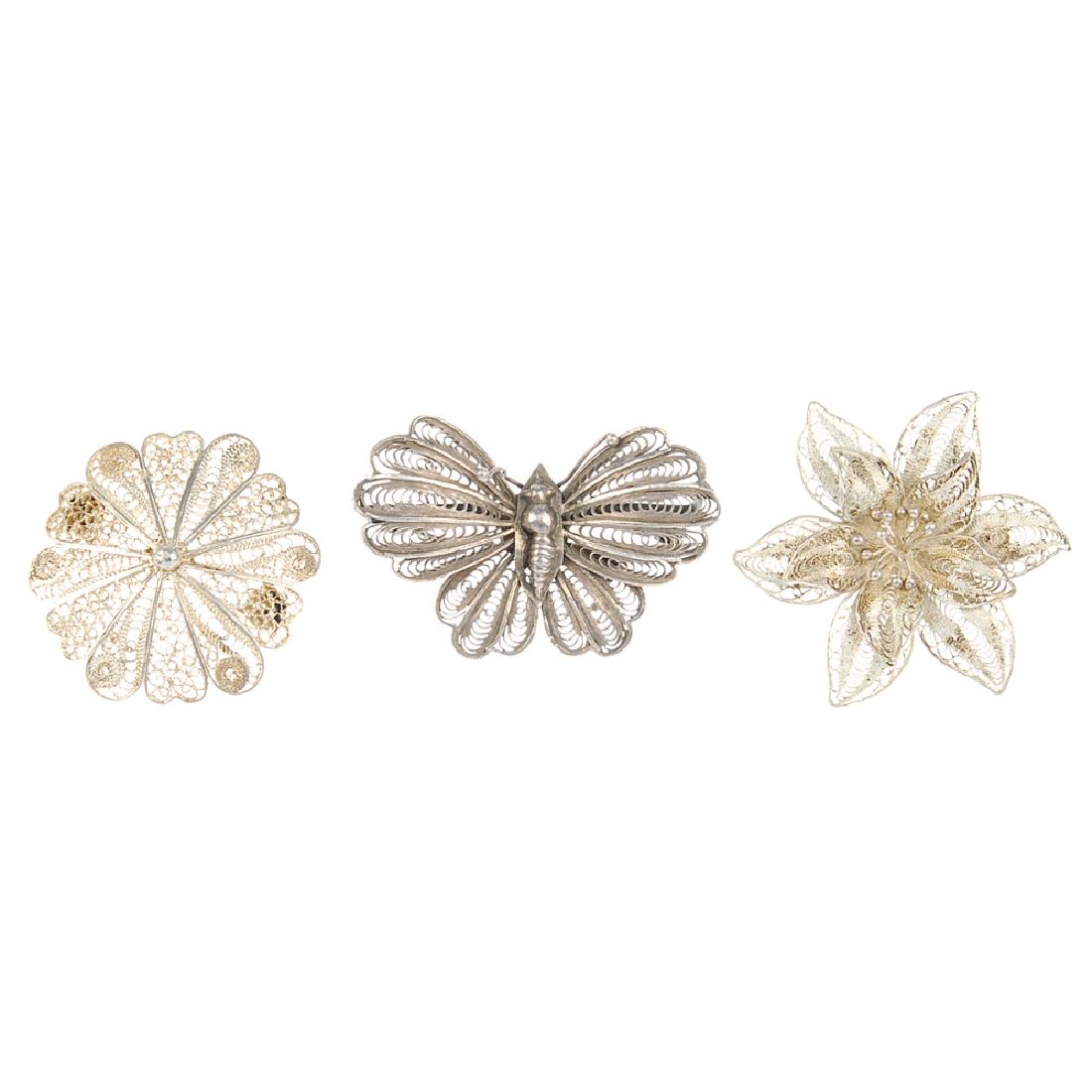 A selection of filigree jewellery. To include a brooch: A selection of filigree jewellery. To include a brooch of butterfly shape, a hinged bangle with pin clasp and scrolling filigree work design and a necklace of openwork spherical beads and an abstract