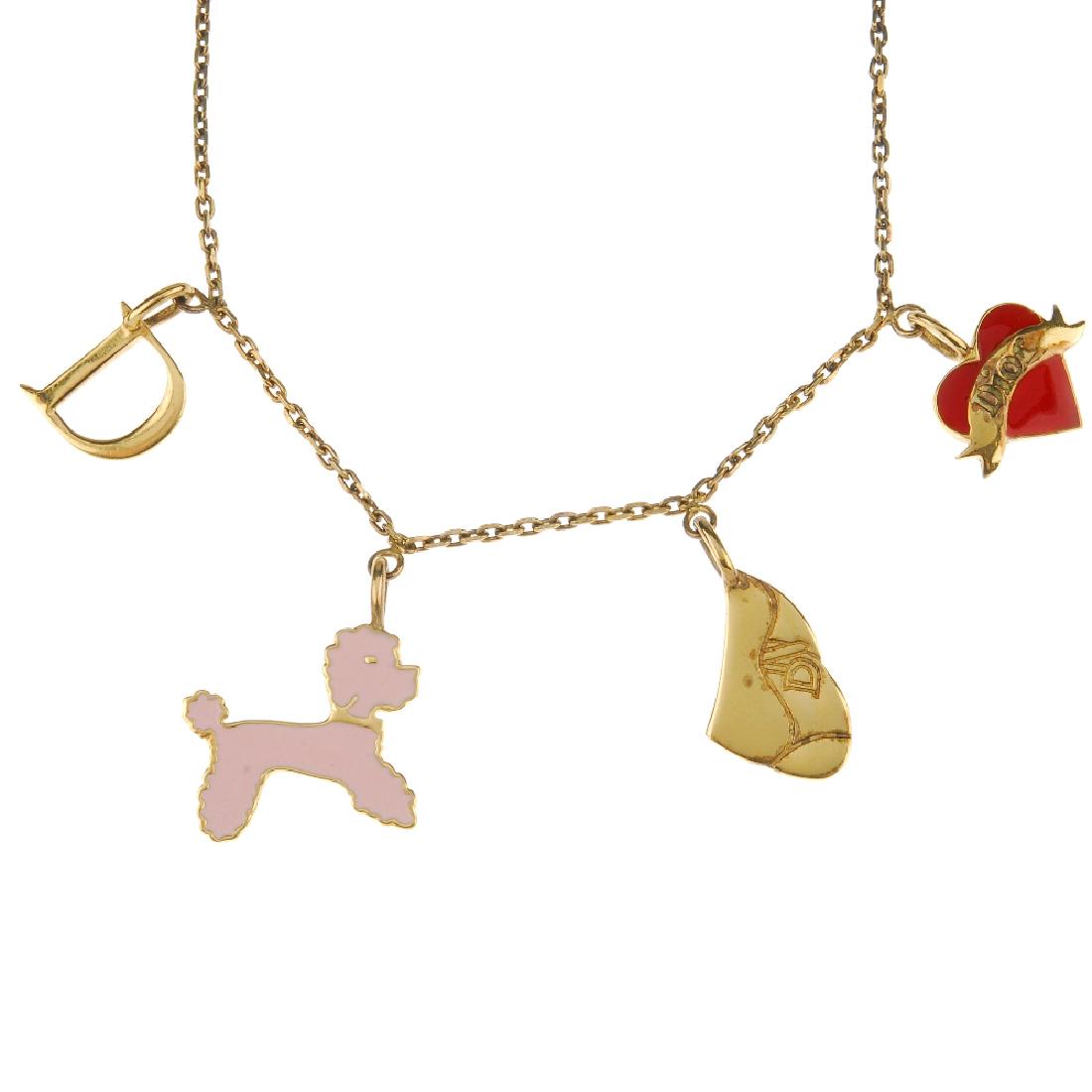 DIOR - a 'Baby Dior' necklace with five charms. The: DIOR - a 'Baby Dior' necklace with five charms. The belcher-link chain suspending five charms, a letter D, a pink enamel poodle, a Dior saddle-style bag, a heart and ribbon charm and a dog bone charm.