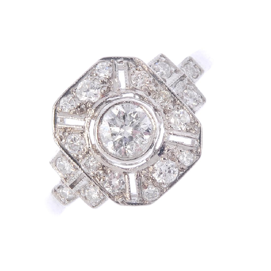 A diamond cluster ring. Of geometric design, the: A diamond cluster ring. Of geometric design, the brilliant-cut diamond collet, with similarly-set openwork panel surround and sides. Estimated total diamond weight 0.65ct. Ring size M. Weight 2.6gms.