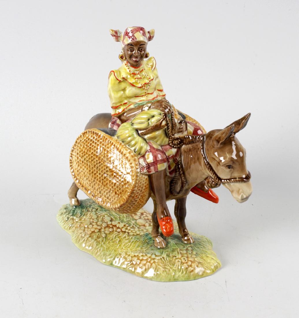 A Beswick figure, 'Susie Jamaica'. Modelled riding upon: A Beswick figure, 'Susie Jamaica'. Modelled riding upon a donkey, model 1347, issued 1954 - 1975, 7, (17.5cm) high.