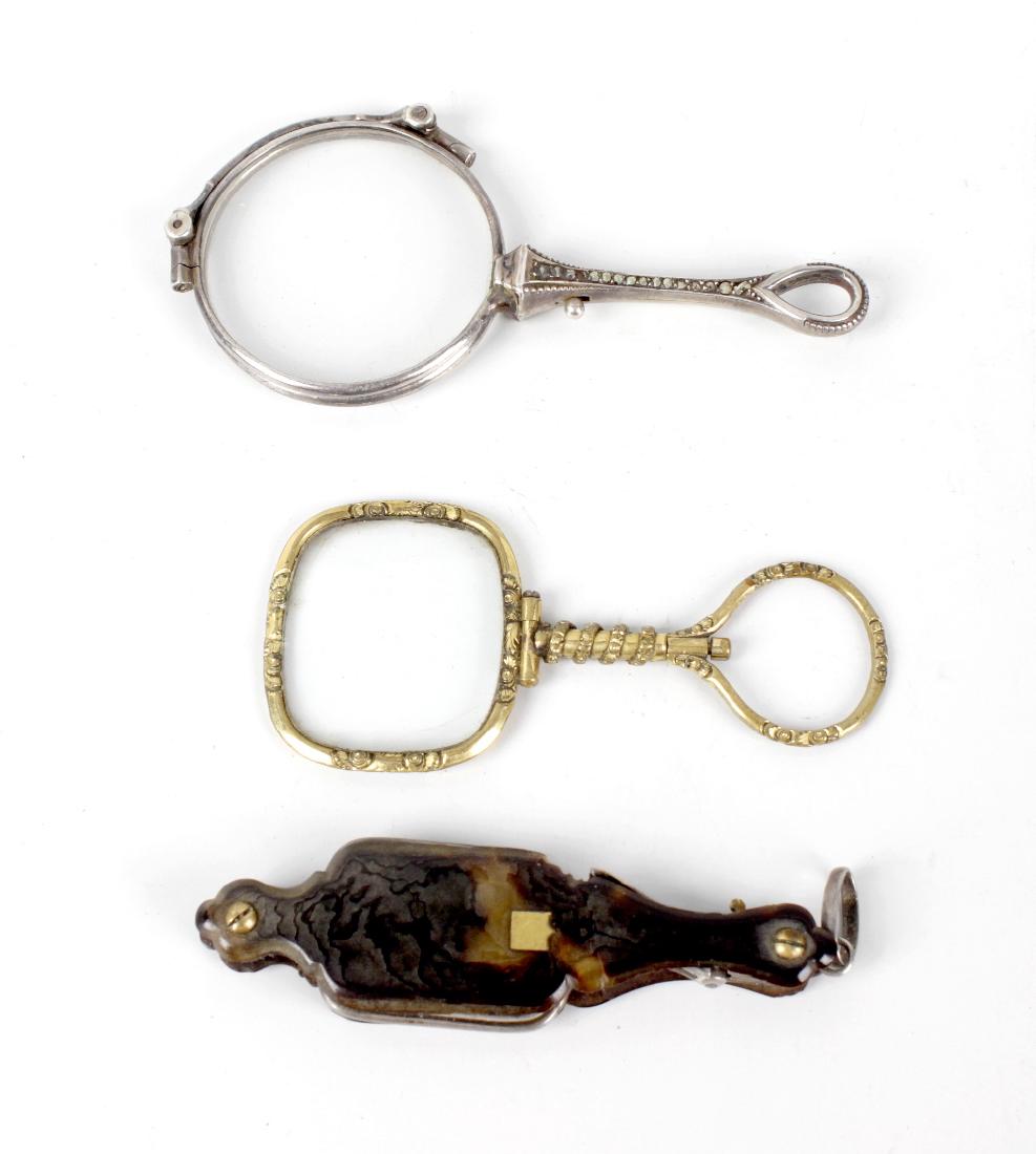 A pair of early 20th century lady's white metal and: A pair of early 20th century lady's white metal and marcasite lorgnettes of folding form, another pair with tortoiseshell mounted case, etc. (3).