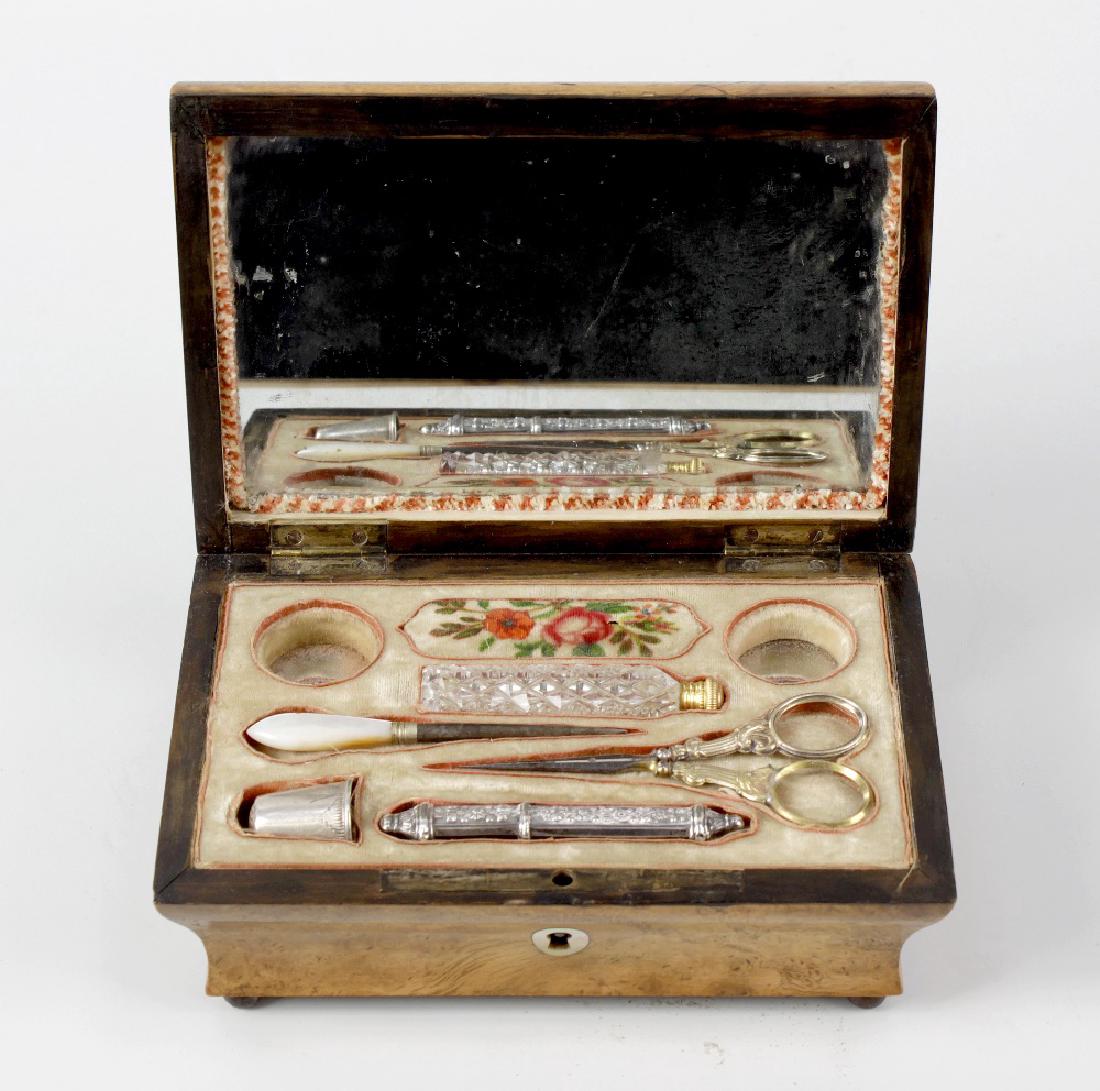 A 19th century burr maple lady's veneered ladies sewing: A 19th century burr maple lady's veneered ladies sewing box, the hinged opening top lifting to reveal a fitted interior with lift out compartmented tray, containing scissors, thimble, and other sewing
