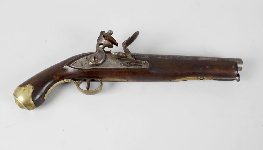 A black powder flint lock pistol, the shaped striker: A black powder flint lock pistol, the shaped striker and pan upon a plate impressed Tower, with furious spurious crown and Georgian monarch marks, the mahogany stock with brass trigger guard and fitti