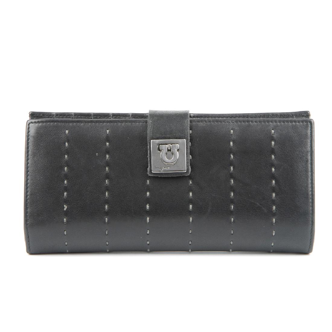 SALVATORE FERRAGAMO - a black Gancini wallet. Crafted: SALVATORE FERRAGAMO - a black Gancini wallet. Crafted from smooth black leather with top stitch detail to the exterior, featuring a silver-tone Gancini logo clip fastening, black leather lining with m
