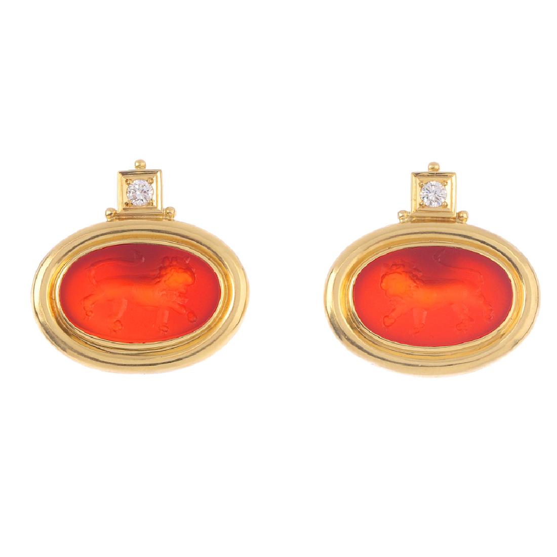 ELIZABETH GAGE - a pair of carnelian intaglio earrings.: ELIZABETH GAGE - a pair of carnelian intaglio earrings. Each designed as an oval carnelian, carved with a lion intaglio, to the grooved surround and brilliant-cut diamond surmount. One back deficient.