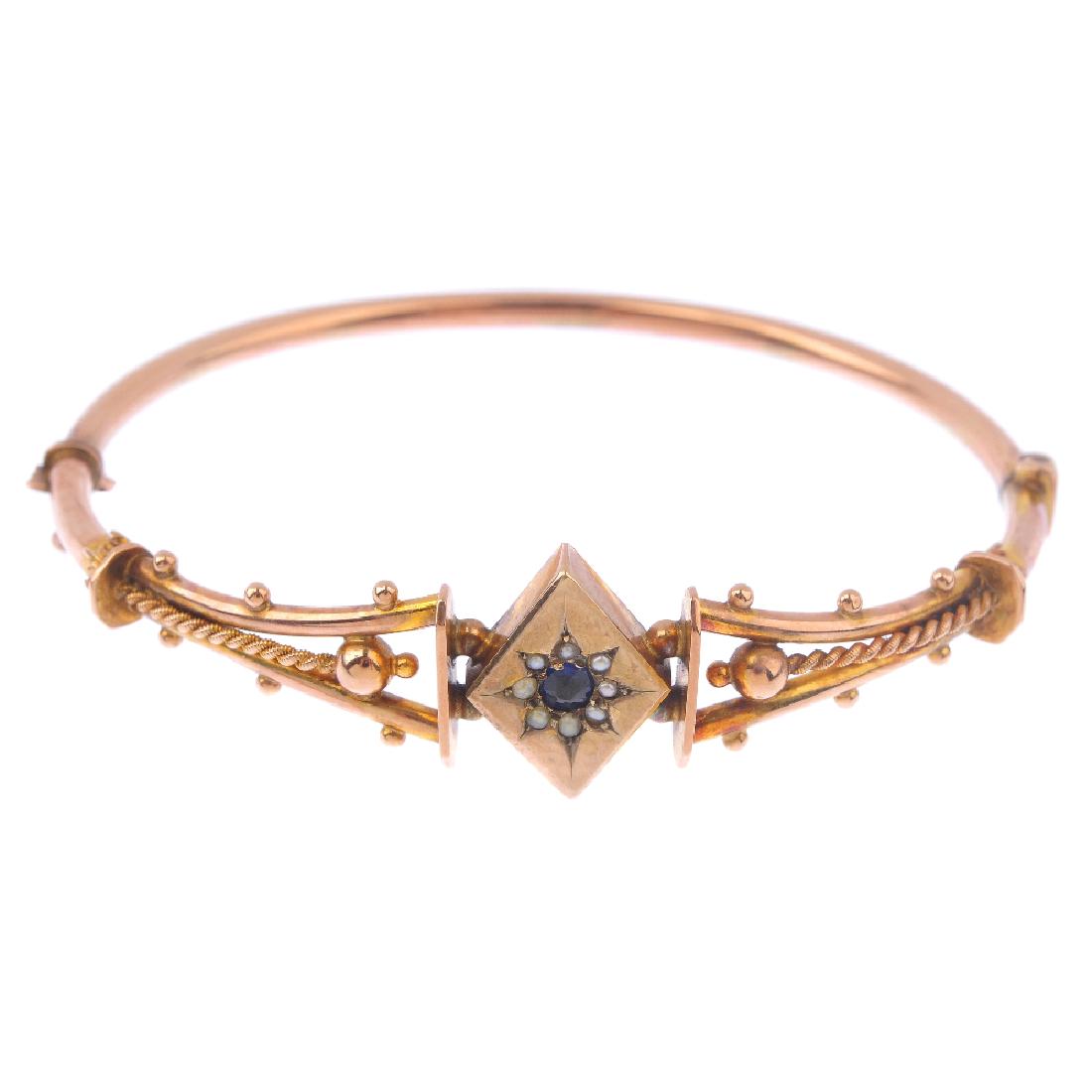 An early 20th century 9ct gold gem-set hinged bangle. (1 of 2)