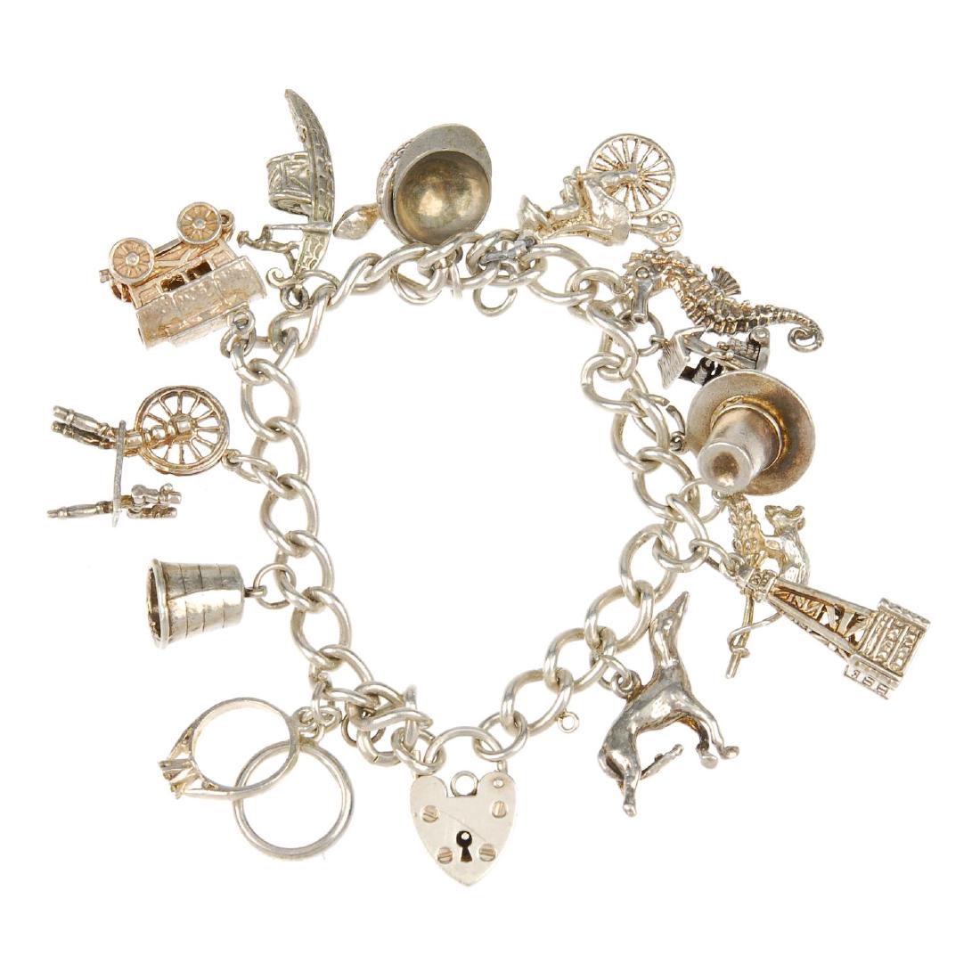 Two charm bracelets. Both curb-link bracelets with: Two charm bracelets. Both curb-link bracelets with heart padlock clasps, suspending a total of thirty charms, to include a spinning wheel and a street lamp. Lengths 16 to 18cms. Weight 95gms.