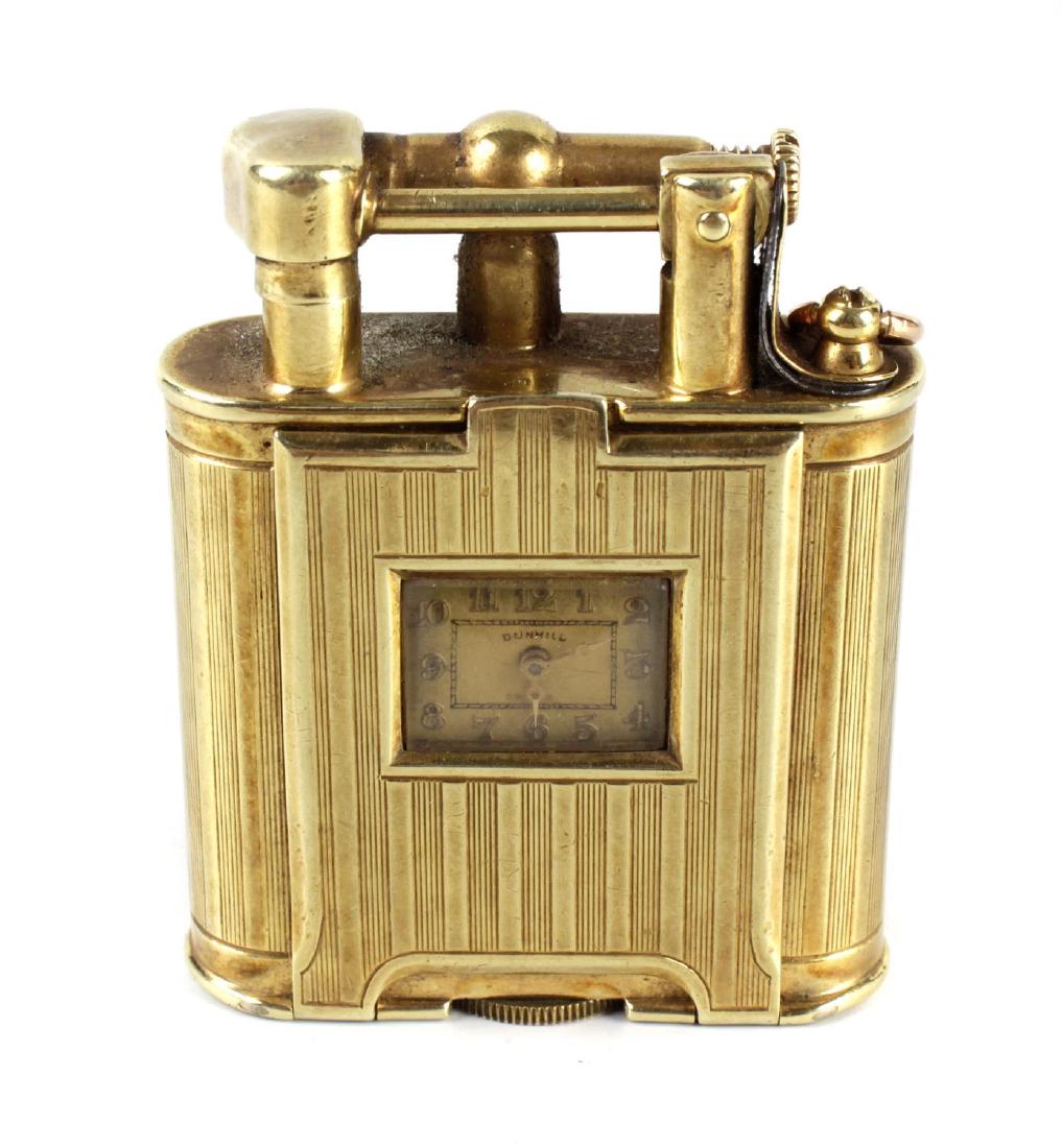 A 14kt gold Dunhill watch 'unique lighter' with roller: A 14kt gold Dunhill watch 'unique lighter' with roller mechanism and hinged arm, the engine turned oblong body with hinged opening door having inset watch with cream dial and Arabic numerals, marked D