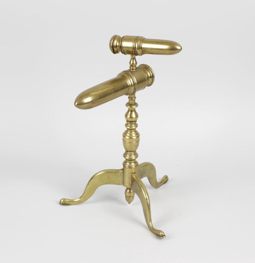 A brass double goffering-iron stand. With graduated: A brass double goffering-iron stand. With graduated sockets on complex turned stem and tripod support with acorn terminal, 11.5, (29cm) high, together with an adjustable trivet with rectangular plate
