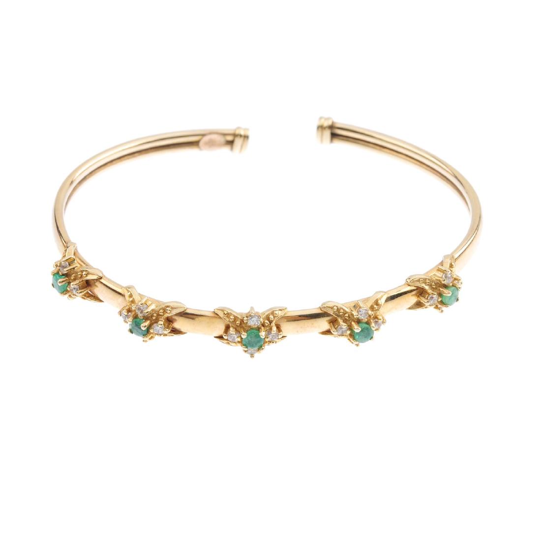 A 9ct gold emerald and cubic zirconia bangle. The cuff (1 of 2)
