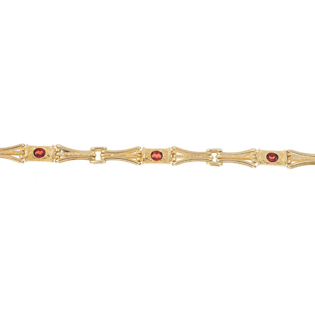 A 9ct gold garnet bracelet. The oval-shape garnet (1 of 3)