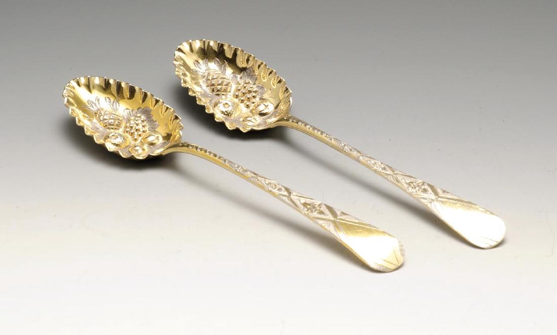 A pair of George III silver-gilt berry spoons, each: A pair of George III silver-gilt berry spoons, each with a crimped rim embossed fruiting bowl and engraved stem with vacant cartouche to the terminal. Hallmarked George Gray, London 1800. Length measu