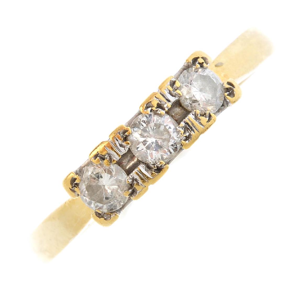An 18ct gold diamond three-stone ring. The (1 of 3)
