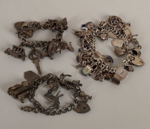 Three silver curb link charm bracelets, charms to: Three silver curb link charm bracelets, charms to include a car, carriage, pram, tea pot. Total weight - 157 grams.