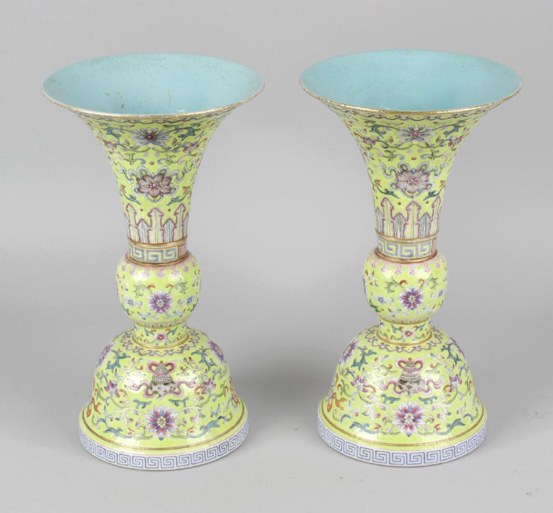 A pair of fine Chinese porcelain famille rose yellow: A pair of fine Chinese porcelain famille rose yellow ground vases, each of gu form with flared trumpet neck upon a bulbous mid section and domed base, the yellow ground enamelled with the eight auspic