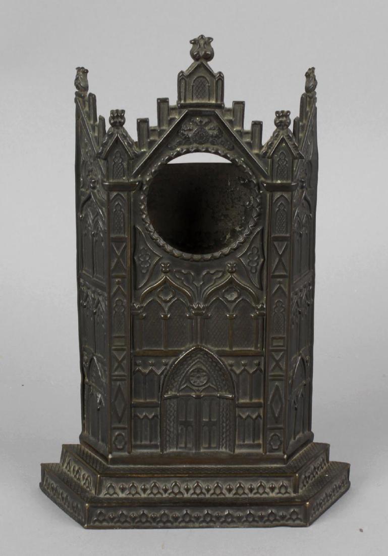 A 19th century bronzed pocket watch stand, formed as: A 19th century bronzed pocket watch stand, formed as the facade of a gothic building, 8.5 (21.5cm) high.