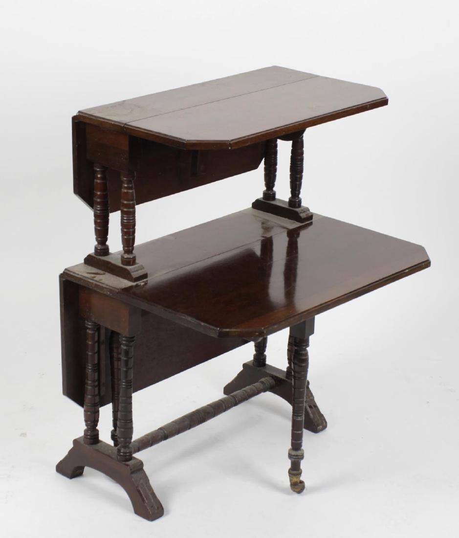 A late Victorian/Edwardian mahogany two-tier Sutherland: A late Victorian/Edwardian mahogany two-tier Sutherland table. Each tier with a pair of canted oblong flaps in ring-turned end standards and stretcher, the lower tier opening on gate-legs, with chamfe