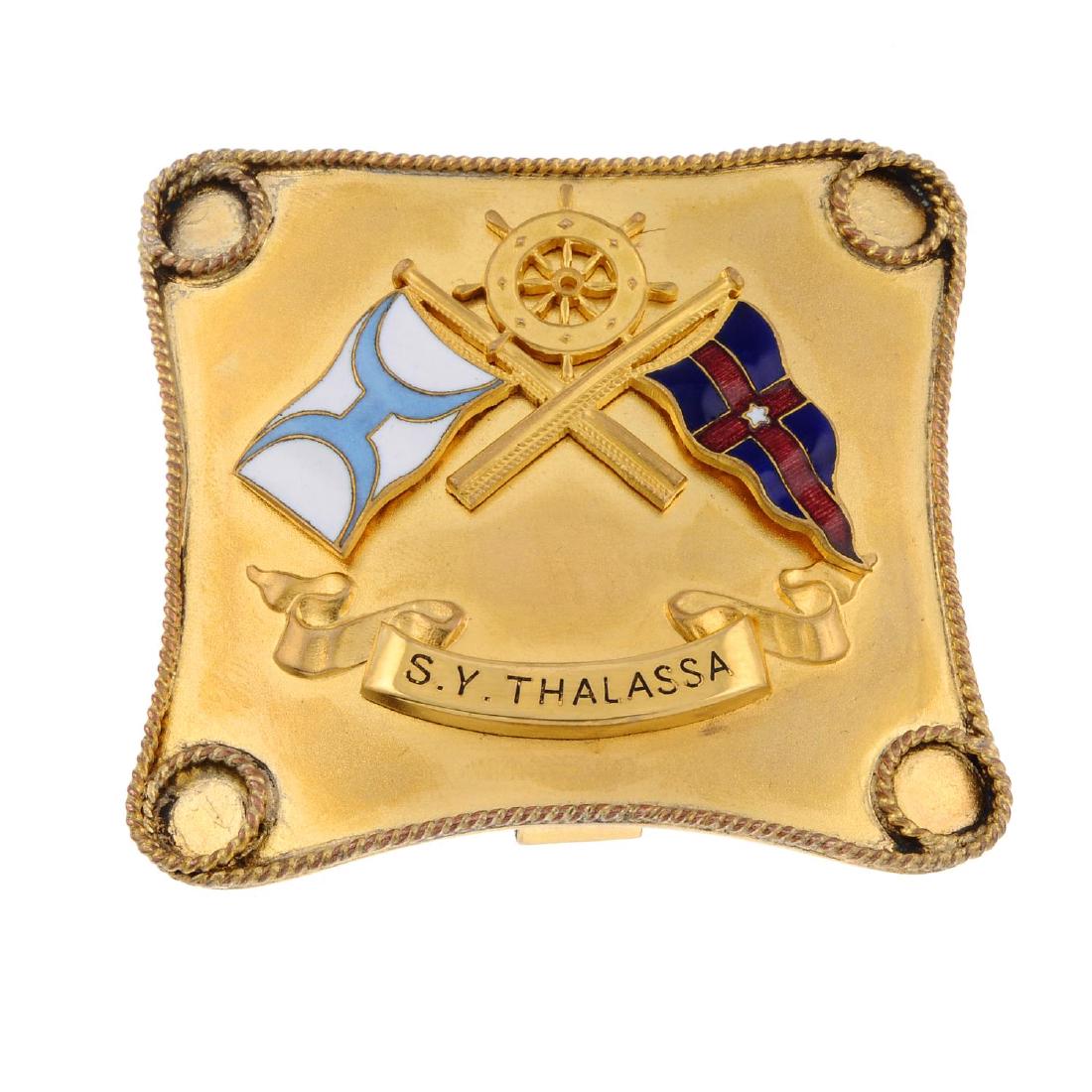 An early 20th century silver gilt buckle. Of square: An early 20th century silver gilt buckle. Of square outline, with applied crossed nautical flags, one pale blue and white, the other red and blue, a ships wheel between them, to the ribbon below for '