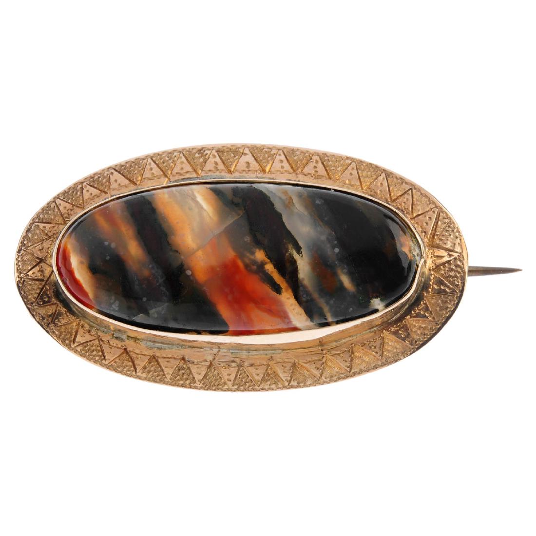 A late 19th century gold Scottish agate brooch. The: A late 19th century gold Scottish agate brooch. The oval agate cabochon, with engraved pyramid motif border. Length 4.5cms. Weight 7gms.