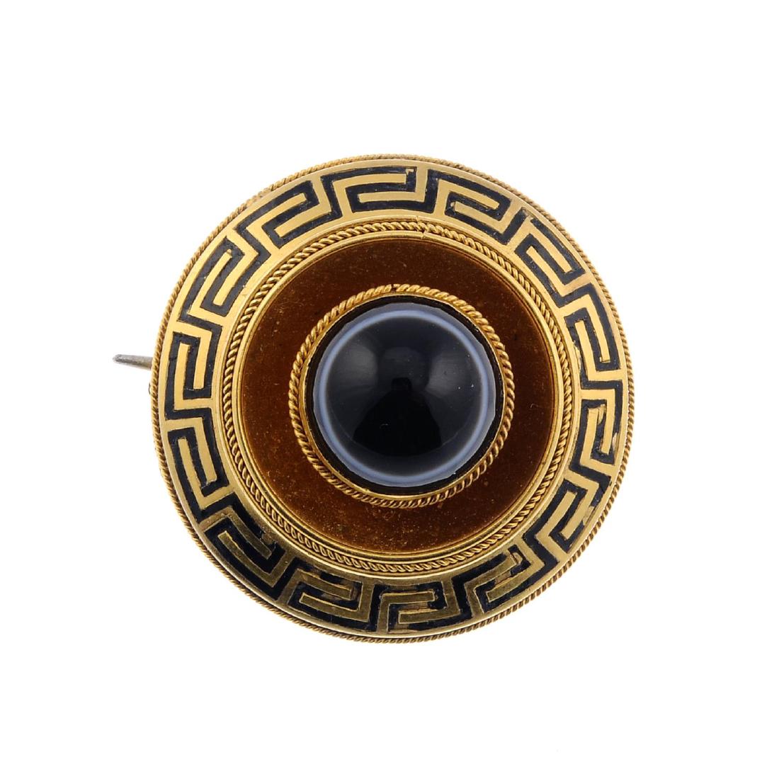 A late Victorian gold banded agate memorial brooch. Of: A late Victorian gold banded agate memorial brooch. Of circular outline, the central circular banded agate cabochon within a rope-twist surround, to the Greek-key border and vacant panel to the revers