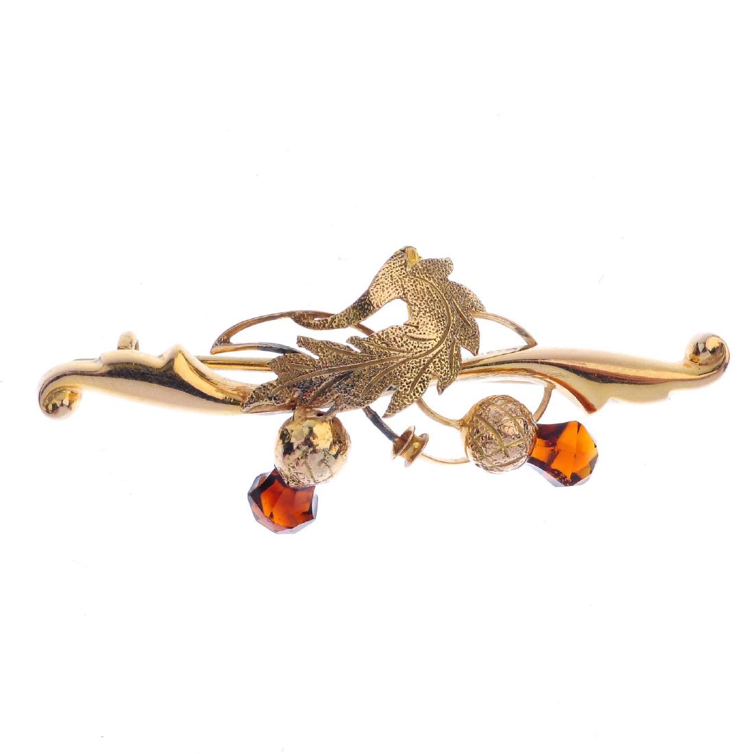 A 9ct gold thistle brooch. The textured foliage with (1 of 2)