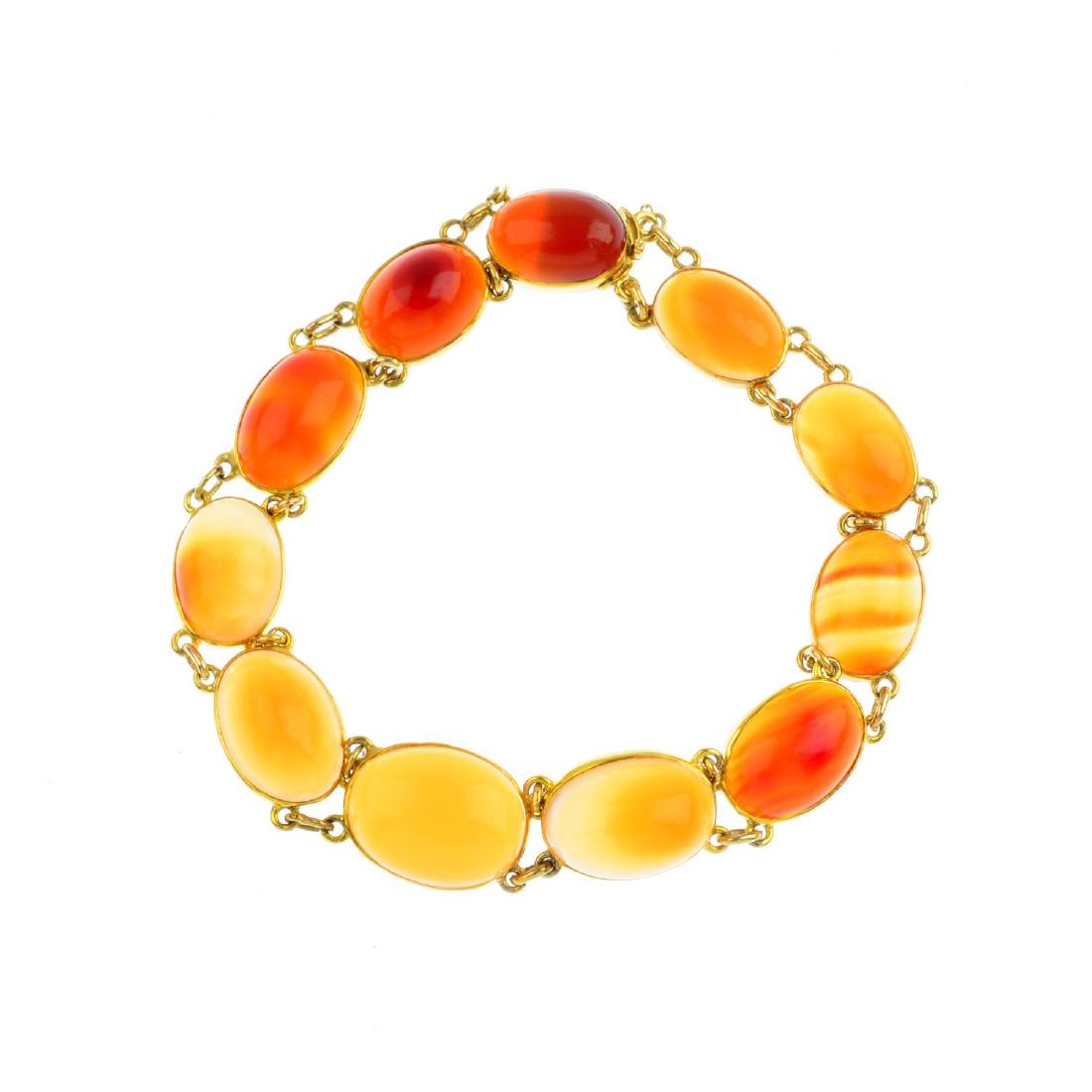 An agate bracelet. Designed as a graduated oval agate: An agate bracelet. Designed as a graduated oval agate cabochon line, with push-piece clasp. Length 19.5cms.