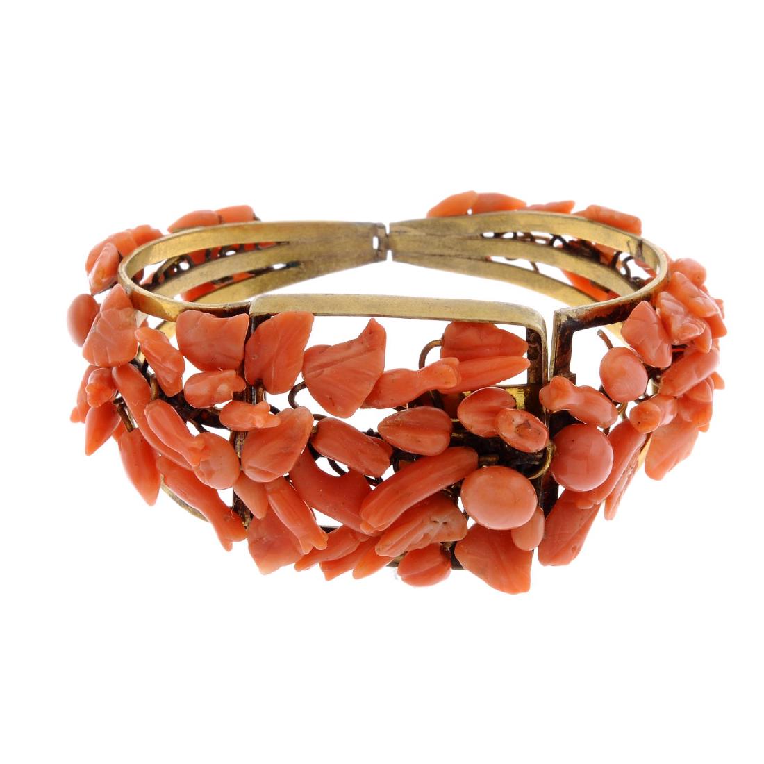 A coral bangle. The hinged bangle set with floral and (1 of 2)