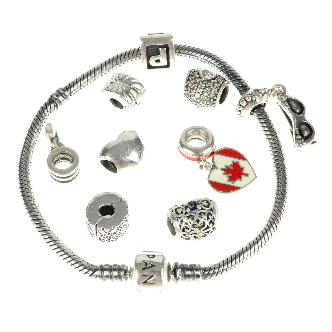 PANDORA - two charm bracelets and a total of eighteen: PANDORA - two charm bracelets and a total of eighteen charms. The bracelet with barrel-shape clasp with two charms, a further ten loose charms including a snowman and a heart, together with a bracelet