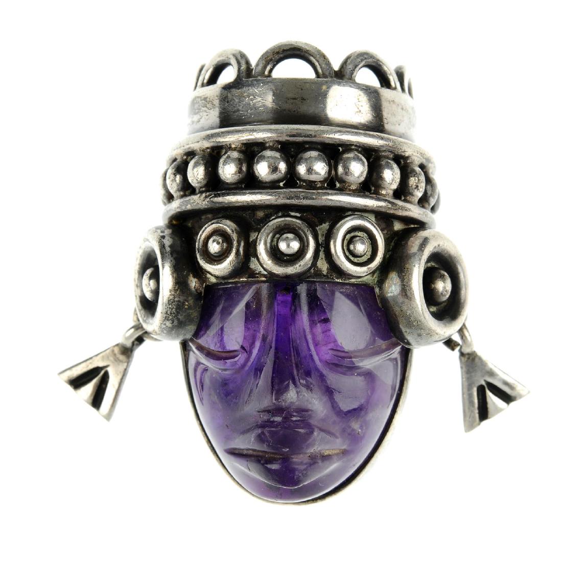 A selection of Mexican jewellery. To include a pendant: A selection of Mexican jewellery. To include a pendant designed as a carved head of amethyst, with headdress and earring detail, marked Taxco, a brooch in the shape of a fish, inlaid with black hardst