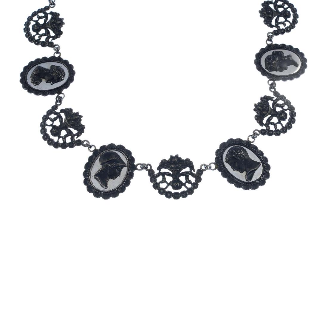 An early 20th century Berlin iron necklace. Comprising: An early 20th century Berlin iron necklace. Comprising a series of alternating cameo plaques on polished steel and floral bouquets, with concealed floral push-piece clasp. Length 50cms.
